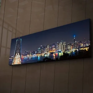 Erbjudande Canvastavla med LED-belysning 30x90 cm - Nattlig stadsbild med en bro och silhuetter av skyskrapor Mörkblå / Ljusgrön / Vit - Inredning