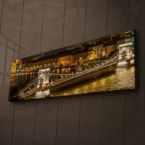 Outlet Canvastavla med LED-belysning 30x90 cm - Nattlig vy av en bro över en flod med upplysta byggnader i bakgrunden Guld / Blå / Svart - Inredning
