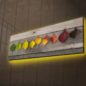 Canvastavla med LED-belysning 30x90 cm - Färgglada löv i en rad på en träplatta Grön / Gul / Röd - Inredning Reapris