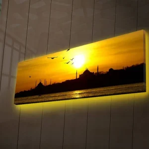 Lägg i varukorgen Canvastavla med LED-belysning 30x90 cm - Solnedgång över en stadssilhuett med fåglar i flykt Guld / Svart / Orange - Inredning